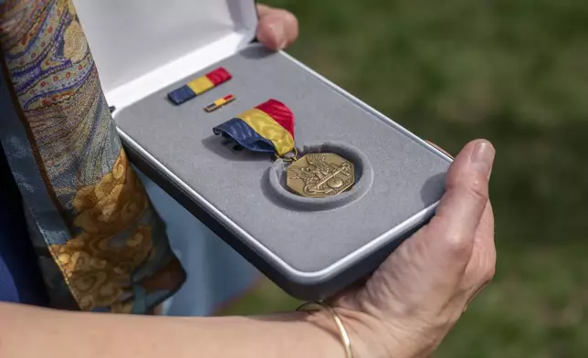 Alexia Collart holds The Navy and Marine Corps Medal, the USMCs highest non-combat medal, that was posthumously awarded to her son, Cpl. Spencer Collart, during a ceremony on Monday, Sept. 16, 2024 in Washington. (AP Photo/Kevin Wolf)