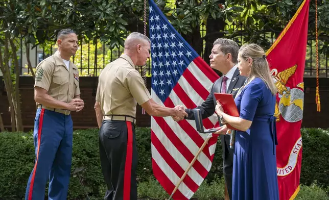 Commandant of the Marine Corps Gen. Eric Smith, center left, presents a the Navy and Marine Corps Medal and citation to Bart Collart and his wife, Alexia, the parents of Cpl. Spencer Collart, during a ceremony on Monday, Sept. 16, 2024 in Washington. (AP Photo/Kevin Wolf)