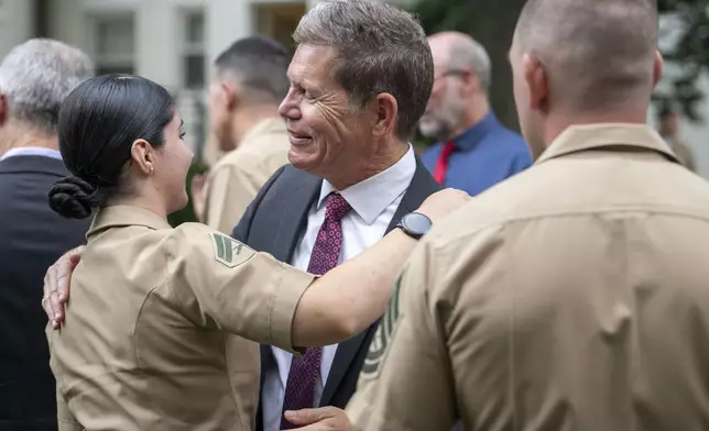 Bart Collart, center, visits with friends of his son, Cpl. Spencer Collart, who was posthumously presented the USMCs highest non-combat medal, The Navy and Marine Corps Medal, during a ceremony on Monday, Sept. 16, 2024 in Washington. (AP Photo/Kevin Wolf)