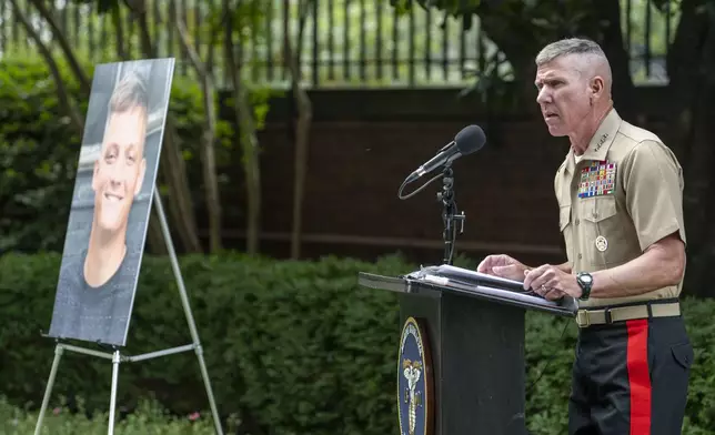 Commandant of the Marine Corps Gen. Eric Smith, speaks during a ceremony posthumously awarding Cpl. Spencer Collart, photo at left, with the Navy and Marine Corps medal on Monday, Sept. 16, 2024 in Washington. (AP Photo/Kevin Wolf)