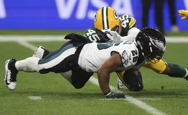 Philadelphia Eagles running back Saquon Barkley (26) is tackled by Green Bay Packers linebacker Eric Wilson (45) during the first half of an NFL football game, Friday, Sept. 6, 2024, at the Neo Quimica Arena in Sao Paulo. (AP Photo/Gregory Payan)