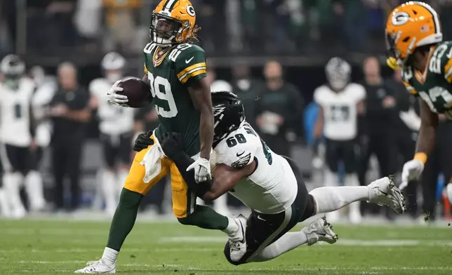 Green Bay Packers safety Xavier McKinney (29) is tackled by Philadelphia Eagles offensive tackle Jordan Mailata (68) during the first half of an NFL football game, Friday, Sept. 6, 2024, at the Neo Quimica Arena in Sao Paulo. (AP Photo/Doug Benc)