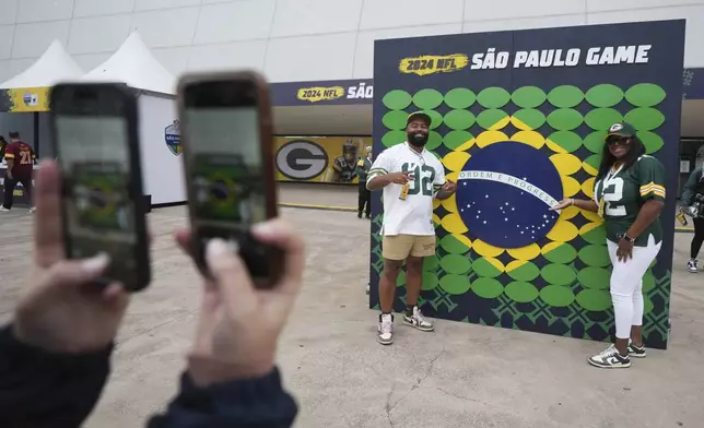 Fans pose before an NFL football game between the Philadelphia Eagles and the Green Bay Packers on Friday, Sept. 6, 2024, at the Neo Quimica Arena in Sao Paulo. (AP Photo/Fernando Llano)