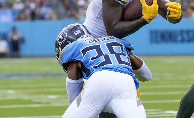 Green Bay Packers' Josh Jacobs is stopped by Tennessee Titans' L'Jarius Sneed during the first half of an NFL football game Sunday, Sept. 22, 2024, in Nashville, Tenn. (AP Photo/George Walker IV)