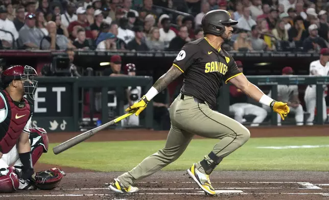 San Diego Padres' David Peralta hits an RBI single against the Arizona Diamondbacks in the first inning during a baseball game, Friday, Sept. 27, 2024, in Phoenix. (AP Photo/Rick Scuteri)