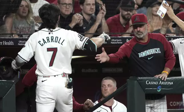 Arizona Diamondbacks' Corbin Carroll (7) celebrates with manager Torey Lovullo, right, after hitting a solo home run against the San Diego Padres in the first inning during a baseball game, Friday, Sept. 27, 2024, in Phoenix. (AP Photo/Rick Scuteri)