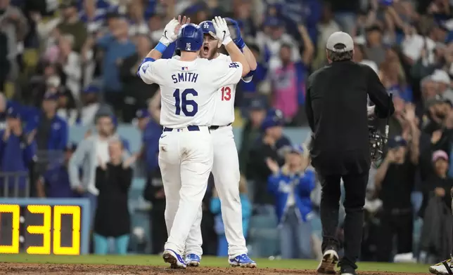 Los Angeles Dodgers' Will Smith (16) celebrates with teammate Max Muncy after hitting a two-run home run during the seventh inning of a baseball game against the San Diego Padres, Thursday, Sept. 26, 2024, in Los Angeles. (AP Photo/Ashley Landis)