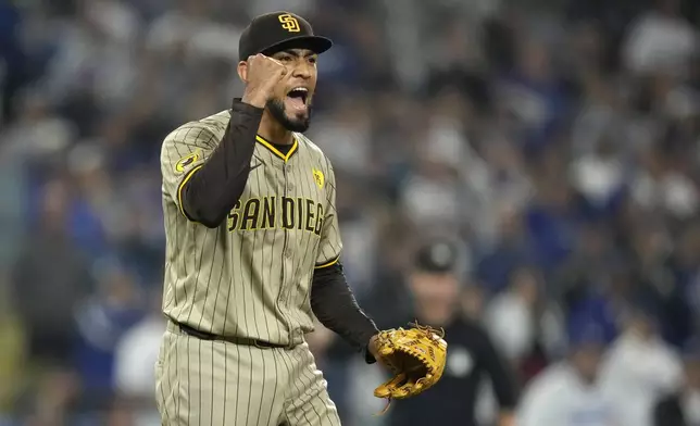 San Diego Padres relief pitcher Robert Suarez celebrates after the Padres clinched a playoff spot with a triple play to end their baseball game against the Los Angeles Dodgers, Tuesday, Sept. 24, 2024, in Los Angeles. (AP Photo/Mark J. Terrill)