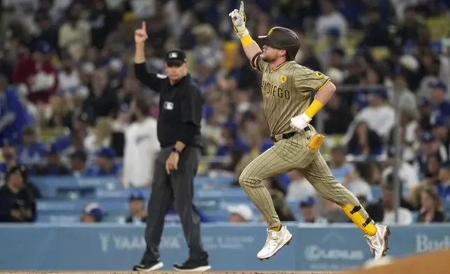 San Diego Padres' Jake Cronenworth, right, gestures as he round first after hitting a two-run home run during the first inning of a baseball game against the Los Angeles Dodgers, Tuesday, Sept. 24, 2024, in Los Angeles. (AP Photo/Mark J. Terrill)