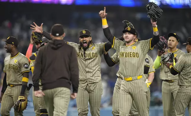 San Diego Padres' Fernando Tatis Jr., center, celebrates with teammates after the Padres clinched a playoff spot with a triple play to end their baseball game against the Los Angeles Dodgers, Tuesday, Sept. 24, 2024, in Los Angeles. (AP Photo/Mark J. Terrill)