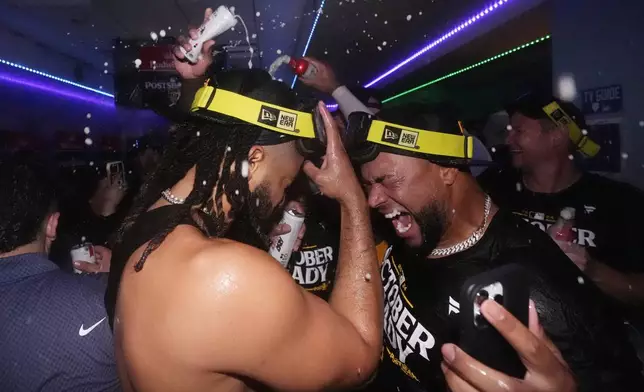 San Diego Padres' Fernando Tatis Jr., left, celebrates with a teammate after the Padres clinched a playoff spot with a triple play to end their baseball game against the Los Angeles Dodgers, Tuesday, Sept. 24, 2024, in Los Angeles. (AP Photo/Mark J. Terrill)