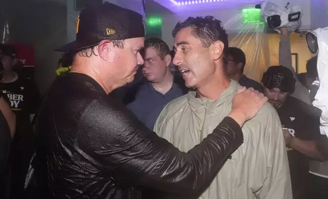 San Diego Padres manager Mike Shildt, left, celebrates with general manager A.J. Preller after the Padres clinched a playoff spot with a triple play to end their baseball game against the Los Angeles Dodgers, Tuesday, Sept. 24, 2024, in Los Angeles. (AP Photo/Mark J. Terrill)