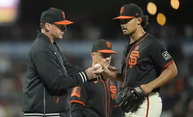 San Francisco Giants manager Bob Melvin, left, takes the ball from pitcher Jordan Hicks, right, during a pitching change in the eighth inning of a baseball game against the San Diego Padres in San Francisco, Saturday, Sept. 14, 2024. (AP Photo/Jeff Chiu)