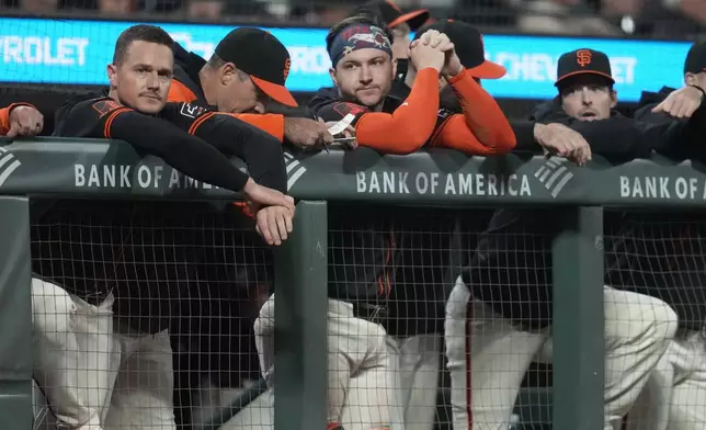 San Francisco Giants' Matt Chapman, left, hitting coach Pat Burrell, second from left, Patrick Bailey, middle, and Mike Yastrzemski, right, watch from the dugout during the eighth inning of a baseball game against the San Diego Padres in San Francisco, Saturday, Sept. 14, 2024. (AP Photo/Jeff Chiu)