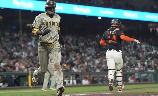 San Diego Padres' Luis Arraez, left, scores past San Francisco Giants catcher Patrick Bailey during the eighth inning of a baseball game in San Francisco, Saturday, Sept. 14, 2024. (AP Photo/Jeff Chiu)