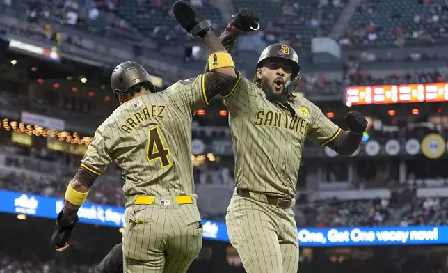 San Diego Padres' Fernando Tatis Jr., right, celebrates after hitting a two-run home run that also scored Luis Arraez (4) during the first inning of a baseball game against the San Francisco Giants in San Francisco, Friday, Sept. 13, 2024. (AP Photo/Jeff Chiu)