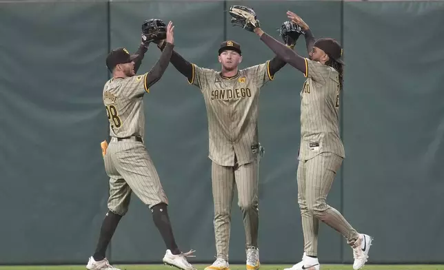 San Diego Padres' Brandon Lockridge, from left, celebrates with Jackson Merrill and Fernando Tatis Jr. after the Padres defeated the San Francisco Giants in a baseball game in San Francisco, Friday, Sept. 13, 2024. (AP Photo/Jeff Chiu)