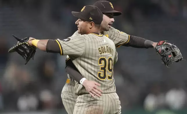 San Diego Padres' Donovan Solano (39) celebrates with third baseman Tyler Wade after the Padres defeated the San Francisco Giants in a baseball game in San Francisco, Saturday, Sept. 14, 2024. (AP Photo/Jeff Chiu)