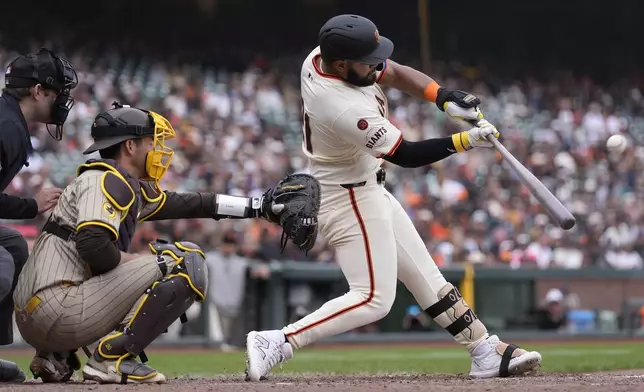 San Francisco Giants' Heliot Ramos, right, hits a home run in front of San Diego Padres catcher Kyle Higashioka during the ninth inning of a baseball game in San Francisco, Sunday, Sept. 15, 2024. (AP Photo/Jeff Chiu)