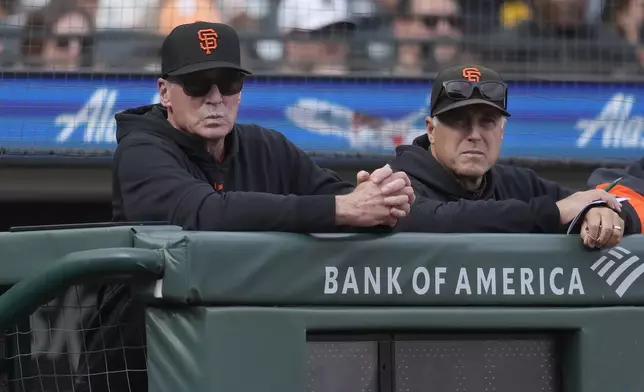 San Francisco Giants manager Bob Melvin, left, and pitching coach Bryan Price watch from the dugout during the ninth inning of a baseball game against the San Diego Padres in San Francisco, Sunday, Sept. 15, 2024. (AP Photo/Jeff Chiu)