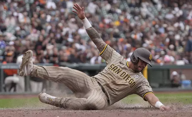 San Diego Padres' David Peralta slides home to score against the San Francisco Giants during the 10th inning of a baseball game in San Francisco, Sunday, Sept. 15, 2024. (AP Photo/Jeff Chiu)