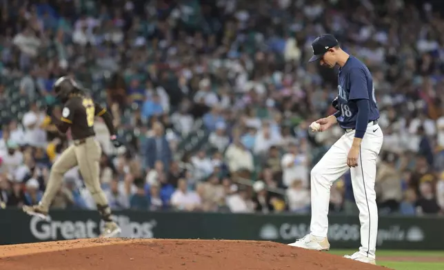 Seattle Mariners starting pitcher George Kirby, right, looks on as San Diego Padres' Fernando Tatis Jr. rounds third base after hitting a three-run home run during the third inning of a baseball game, Tuesday, Sept. 10, 2024, in Seattle. (AP Photo/Jason Redmond)