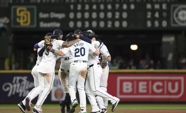 Seattle Mariners players celebrate after defeating the San Diego Padres in a baseball game, Wednesday, Sept. 11, 2024, in Seattle. (AP Photo/Jason Redmond)