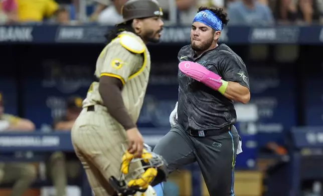 Tampa Bay Rays' Jonathan Aranda scores in front of San Diego Padres catcher Luis Campusano on an RBI single by Christopher Morel during the fifth inning of a baseball game Saturday, Aug. 31, 2024, in St. Petersburg, Fla. (AP Photo/Chris O'Meara)