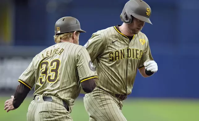 San Diego Padres' Jake Cronenworth celebrates his two-run home run off Tampa Bay Rays starting pitcher Shane Baz with third base coach, infield &amp; base running instructor Tim Leiper (33) during the first inning of a baseball game Saturday, Aug. 31, 2024, in St. Petersburg, Fla. (AP Photo/Chris O'Meara)