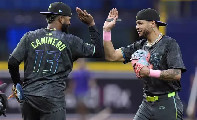 Tampa Bay Rays' Jose Siri celebrates with Junior Caminero (13) after the team defeated the San Diego Padres during a baseball game Saturday, Aug. 31, 2024, in St. Petersburg, Fla. (AP Photo/Chris O'Meara)