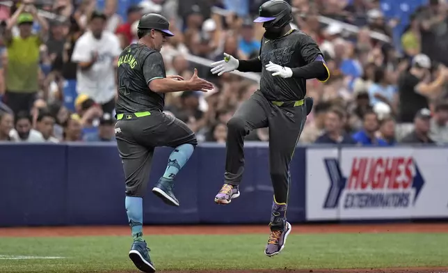 Tampa Bay Rays' Junior Caminero, right, celebrates his three-run home run off San Diego Padres starting pitcher Randy Vasquez with third base coach Brady Williams during the second inning of a baseball game Saturday, Aug. 31, 2024, in St. Petersburg, Fla. (AP Photo/Chris O'Meara)