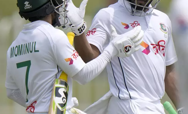 Bangladesh's Mominul Haque, left, celebrates with Najmul Hossain Shanto as they walk off the field on the lunch break during the fifth day of second test cricket match between Pakistan and Bangladesh, in Rawalpindi, Pakistan, Tuesday, Sept. 3, 2024. (AP Photo/Anjum Naveed)