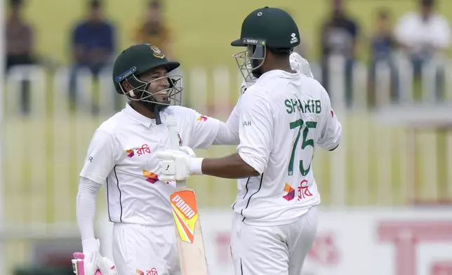 Bangladesh's Mushfiqur Rahim, left, celebrates with Shakib Al Hasan after winning the second test cricket match against Pakistan, in Rawalpindi, Pakistan, Tuesday, Sept. 3, 2024. (AP Photo/Anjum Naveed)