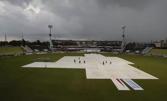 Ground staff cover the pitch after game stop due to bad light during the fourth day of second test cricket match between Pakistan and Bangladesh, in Rawalpindi, Pakistan, Monday, Sept. 2, 2024. (AP Photo/Anjum Naveed)