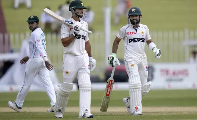 Pakistan's Mohammad Rizwan, right, and Pakistan's Salman Ali Agha, center, walk during the fourth day of second test cricket match between Pakistan and Bangladesh, in Rawalpindi, Pakistan, Monday, Sept. 2, 2024. (AP Photo/Anjum Naveed)