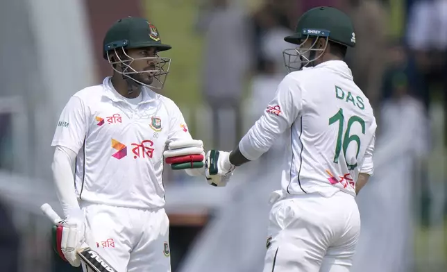 Bangladesh's Mehidy Hasan Mirza, left, bumps his fist with Litton Das during the third day of second test cricket match between Pakistan and Bangladesh, in Rawalpindi, Pakistan, Sunday, Sept. 1, 2024. (AP Photo/Anjum Naveed)