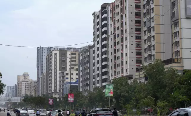 Vehicles and motorcycles move through a road with high-rise apartment buildings in Karachi, Pakistan, Thursday, Aug. 29, 2024. (AP Photo/Fareed Khan)