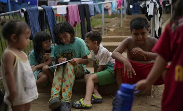 Children play at a camp for migrants in Lajas Blancas, Panama, after walking across the Darien Gap in hopes of reaching the U.S., Thursday, Sept. 26, 2024. (AP Photo/Matias Delacroix)