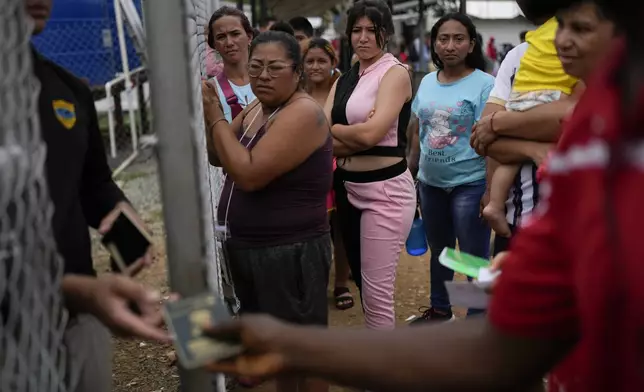 Migrants wait to get back their passports as Panamanian immigration officers process their identifications at a post where those who trekked across the Darién Gap stop along their way north toward the U.S., in Lajas Blancas, Panama, Thursday, Sept. 26, 2024. (AP Photo/Matias Delacroix)