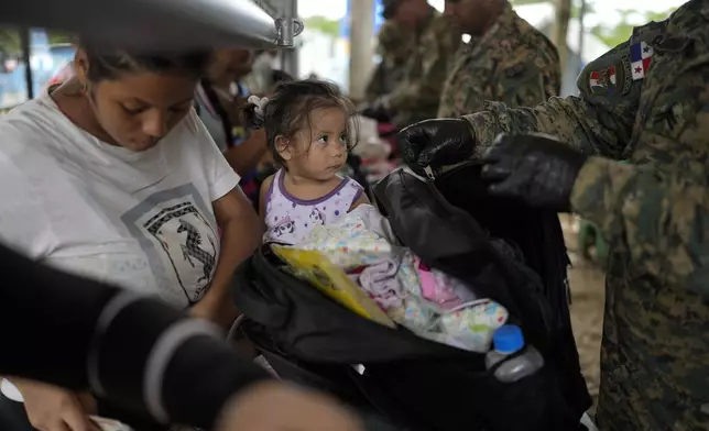 Panamanian police inspect the luggage of Francismar Acosta, from Venezuela, in Lajas Blancas, Panama, after she trekked across the Darien Gap from Colombia with her daughter Adhara Figueroa, Thursday, Sept. 26, 2024. (AP Photo/Matias Delacroix)