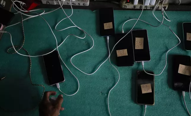 The cell phones of migrants get their batteries charged for a cost of $1 dollar per hour at a camp for people who walked across the Darien Gap in hopes of reaching the U.S., in Lajas Blancas, Panama, Thursday, Sept. 26, 2024. (AP Photo/Matias Delacroix)