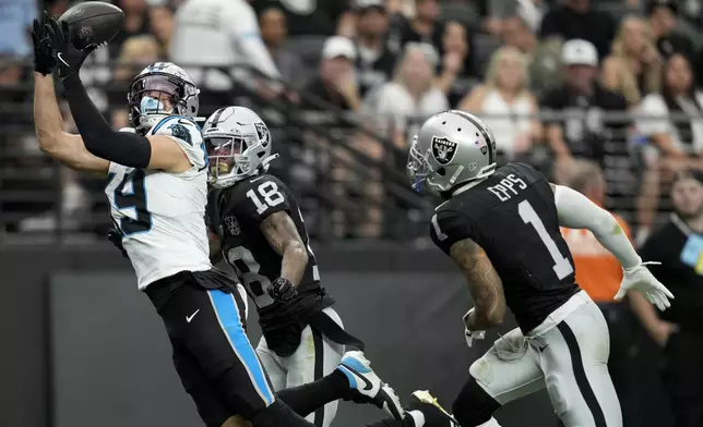 Carolina Panthers wide receiver Adam Thielen scores ahead of Las Vegas Raiders cornerback Jack Jones during the first half of an NFL football game, Sunday, Sept. 22, 2024, in Las Vegas. (AP Photo/John Locher)