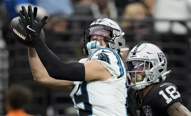 Carolina Panthers wide receiver Adam Thielen scores ahead of Las Vegas Raiders cornerback Jack Jones during the first half of an NFL football game, Sunday, Sept. 22, 2024, in Las Vegas. (AP Photo/John Locher)