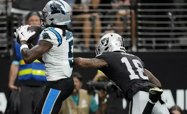 Carolina Panthers wide receiver Diontae Johnson scores past Las Vegas Raiders cornerback Jack Jones during the first half of an NFL football game, Sunday, Sept. 22, 2024, in Las Vegas. (AP Photo/John Locher)