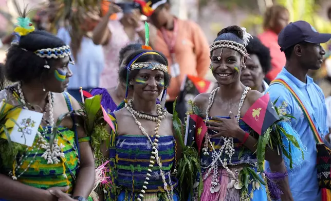 People dressed in traditional attire wait for the arrival of Pope Francis at Caritas Technical Secondary School in Port Moresby, Papua New Guinea, Saturday, Sept. 7, 2024. (AP Photo/Mark Baker)