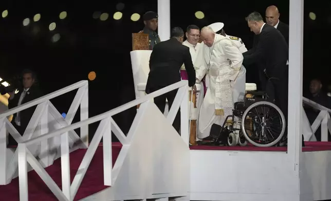 Pope Francis is helped down a ramp at Jackson's International Airport in Port Moresby, Papua New Guinea, Friday, Sept. 6, 2024. (AP Photo/Mark Baker)