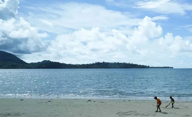 Children draw Crosses on a sandy beach in Vanimo, Papua New Guinea, Sunday, Sept. 8, 2024. Pope Francis celebrated the Catholic Church of the peripheries on Sunday as he traveled to the remote jungles of Papua New Guinea, bringing with him a ton of medicine and toys and a message of love overcoming violence for the people who live there.(AP Photo/Gregorio Borgia)