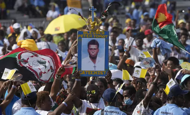 Attendees hoist a picture of blessed Peter To Rot, a catechist who was killed during the Japanese occupation in 1945 and beatified in 1995, during a meeting between Pope Francis and young people at the Sir John Guise stadium in Port Moresby, Monday, Sept. 9, 2024. (AP Photo/Gregorio Borgia)