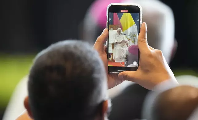 A participant take video of Pope Francis deliver delivering his speech at APEC Haus in Port Moresby, Papua New Guinea, Saturday, Sept. 7, 2024. (AP Photo/Mark Baker)