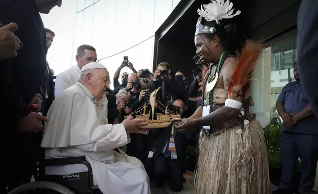 Pope Francis receives souvenir from a Papua New Guinea traditional dancer at APEC Haus in Port Moresby, Papua New Guinea, Saturday, Sept. 7, 2024. (AP Photo/Mark Baker)